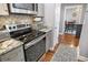 Kitchen with stainless steel stove and gray cabinetry open to adjacent rooms at 750 N Tamiami Trl # 604, Sarasota, FL 34236