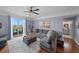 Spacious living room featuring hardwood floors, an expansive sectional sofa, and balcony access at 750 N Tamiami Trl # 604, Sarasota, FL 34236