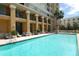 Community pool with lounge seating and building views, offering a relaxing retreat at 750 N Tamiami Trl # 604, Sarasota, FL 34236