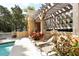 Outdoor patio area with hot tub and lounge chairs, surrounded by plants and a wooden pergola at 750 N Tamiami Trl # 604, Sarasota, FL 34236