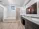 A bathroom with white walls, wood look floors, a standalone tub, and a walk-in shower at 7604 49Th E Ave, Bradenton, FL 34203