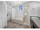 A bathroom with white walls, wood look floors, a standalone tub, and a walk-in shower at 7604 49Th E Ave, Bradenton, FL 34203