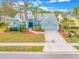 Charming single-story home with a teal exterior, lush landscaping, and a two-car garage at 7604 49Th E Ave, Bradenton, FL 34203