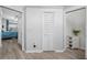 Hallway with wood-style floors, white trim, and bi-fold doors leading to the bedroom and other parts of the home at 7604 49Th E Ave, Bradenton, FL 34203