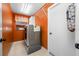 Well-lit laundry room with a stacked washer/dryer, storage shelves, and an ironing board at 7604 49Th E Ave, Bradenton, FL 34203