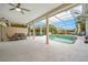 Relaxing screened-in pool area with spa, outdoor dining, lounge chairs, and a ceiling fan at 7604 49Th E Ave, Bradenton, FL 34203