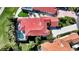 Stunning aerial view of a Mediterranean-style home with a red tile roof and screened-in pool at 8025 Via Fiore, Sarasota, FL 34238
