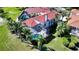 Aerial view of home with manicured landscaping, screened pool, and red tile roof at 8025 Via Fiore, Sarasota, FL 34238