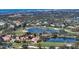 Aerial view of community showcasing lush landscaping, sparkling water features, and manicured golf course at 8025 Via Fiore, Sarasota, FL 34238