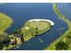 Unique aerial shot of a golf course island surrounded by a lake in a peaceful community with blue skies above at 8025 Via Fiore, Sarasota, FL 34238