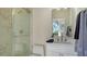 Bright bathroom with a glass shower, modern fixtures, and a sleek white vanity at 8025 Via Fiore, Sarasota, FL 34238