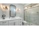 An elegant bathroom featuring marble shower, sconces, and modern fixtures at 8025 Via Fiore, Sarasota, FL 34238