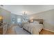 Comfortable bedroom with hardwood floors, chandelier, and large windows at 8025 Via Fiore, Sarasota, FL 34238