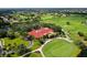 Aerial view of a golf course clubhouse surrounded by lush landscaping and green fairways at 8025 Via Fiore, Sarasota, FL 34238
