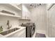 Well-equipped laundry room with modern appliances, sink, and storage solutions at 8025 Via Fiore, Sarasota, FL 34238