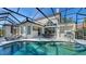 Inviting screened-in pool area with outdoor kitchen, dining, and lounge spaces perfect for Florida living at 8025 Via Fiore, Sarasota, FL 34238