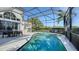 Inviting screened-in pool and outdoor dining area with serene water views at 8025 Via Fiore, Sarasota, FL 34238