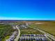 An expansive aerial view captures a Primary-planned community near a large expanse of grassy land and blue skies at 8262 Velda Trl, Sarasota, FL 34241