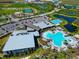 Aerial view of community amenities featuring a resort style pool, lap pool, clubhouse, tennis courts and athletic fields at 8262 Velda Trl, Sarasota, FL 34241
