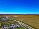 Expansive aerial shot showcasing a residential area bordered by green fields and a distant horizon at 8262 Velda Trl, Sarasota, FL 34241