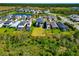 An aerial view displays a home with a spacious backyard, situated near a serene pond in a residential area at 8262 Velda Trl, Sarasota, FL 34241