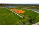 Aerial view of neighborhood sports fields with green lawns and scenic water views at 8262 Velda Trl, Sarasota, FL 34241