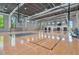 Spacious indoor basketball court with hardwood floors, basketball hoops, and bleacher seating at 8262 Velda Trl, Sarasota, FL 34241