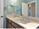 Bathroom featuring double sinks, vanity, and a large mirror at 8262 Velda Trl, Sarasota, FL 34241