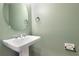 Charming half bathroom with a pedestal sink, modern fixtures, and a round mirror at 8262 Velda Trl, Sarasota, FL 34241