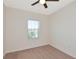 The bedroom features neutral carpet, and a large window for natural light and fresh air at 8262 Velda Trl, Sarasota, FL 34241