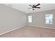 A bedroom features carpet floors, light walls, a ceiling fan, and multiple windows at 8262 Velda Trl, Sarasota, FL 34241