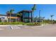 Modern clubhouse with large glass windows, surrounded by palm trees and ample parking at 8262 Velda Trl, Sarasota, FL 34241
