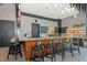 Modern community center kitchen with a stone countertop, bar stools, and pendant lighting at 8262 Velda Trl, Sarasota, FL 34241