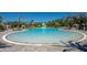 Expansive lagoon-style pool with zero entry, beach, water slide, and tropical landscaping at 8262 Velda Trl, Sarasota, FL 34241