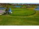 Aerial shot of a fenced dog park featuring covered benches and open grassy areas near ponds in a residential area at 8262 Velda Trl, Sarasota, FL 34241