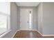 Bright foyer with a large white front door, light-gray walls, and wood-look floors at 8262 Velda Trl, Sarasota, FL 34241