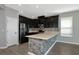 Kitchen showcasing dark cabinetry, stainless steel appliances, and stone-accented breakfast bar at 8262 Velda Trl, Sarasota, FL 34241