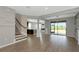 Open concept living area with hardwood floors, staircase, and view of the yard through large sliding glass doors at 8262 Velda Trl, Sarasota, FL 34241
