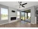 Living room showcasing fireplace, ceiling fan, and sliding glass doors to the outdoor patio at 8262 Velda Trl, Sarasota, FL 34241