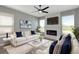 Bright living room featuring a fireplace, large windows, white furniture, and navy blue throw pillows at 8262 Velda Trl, Sarasota, FL 34241