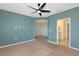 The main bedroom features neutral carpet, a ceiling fan, and direct access to an ensuite bathroom at 8262 Velda Trl, Sarasota, FL 34241