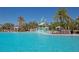 Resort-style pool with a splash pad, surrounded by cabanas and lounge chairs for relaxation at 8262 Velda Trl, Sarasota, FL 34241