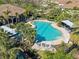 Aerial view of a pool, beautiful landscaping, and nearby residential buildings within the community at 8323 Enclave Way # 104, Sarasota, FL 34243