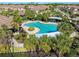 Aerial view of community pool with landscaping, sunshades, lounge chairs, and nearby community housing at 8323 Enclave Way # 104, Sarasota, FL 34243
