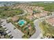 Aerial view highlighting the Soleil community pool and surrounding villas, showcasing landscaping, parking and street layout at 8323 Enclave Way # 104, Sarasota, FL 34243