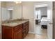 Bathroom with double sinks, granite countertops, and an open doorway to the bedroom at 8323 Enclave Way # 104, Sarasota, FL 34243