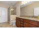 En suite bathroom with double sinks, wooden cabinetry, and a tiled walk-in shower at 8323 Enclave Way # 104, Sarasota, FL 34243