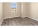 Bright bedroom with wood-look flooring and a large window overlooking the neighborhood at 8323 Enclave Way # 104, Sarasota, FL 34243