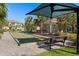 Bocce ball court with bench, sunshades, picnic tables, and lush landscaping for a relaxing game with neighbors at 8323 Enclave Way # 104, Sarasota, FL 34243