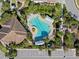 Aerial view of resort-style pool with lounge area and mature landscaping for relaxation at 8323 Enclave Way # 104, Sarasota, FL 34243